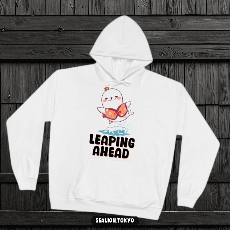 Funny hoodie depicting a sea lion in a festive kimono, joyfully leaping over a small wave, radiating pure happiness.