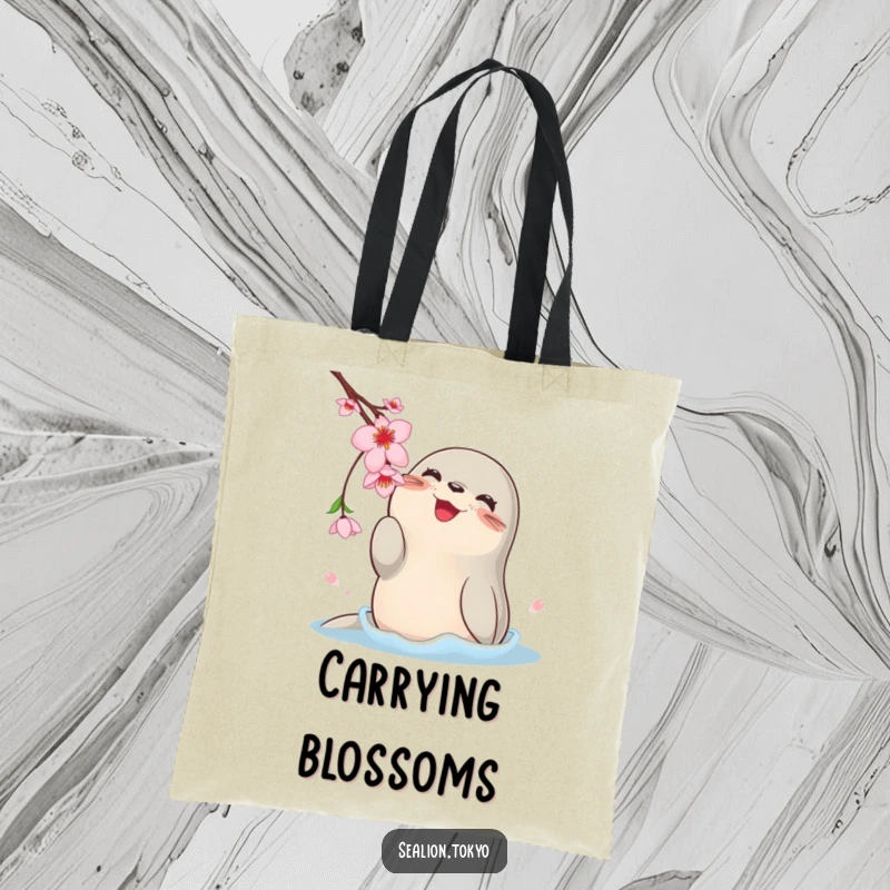 Funny tote bag depicting a happy, rotund sea lion playfully swatting at a dangling cherry blossom with its flippers.